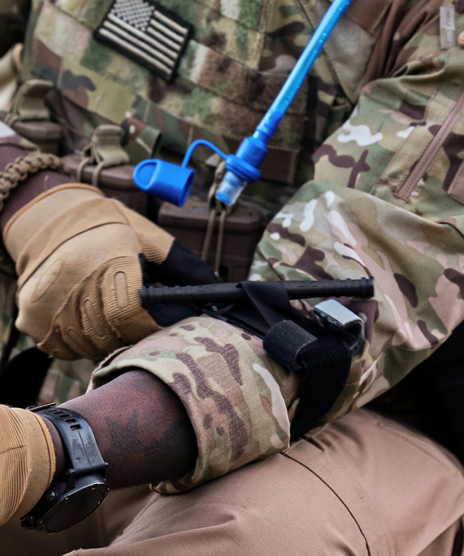 person in a military uniform holding tactical gear
