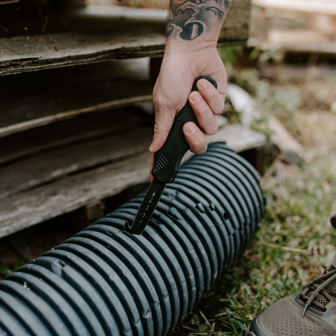 large size krt sentinel otf knife puncturing a drainage pipe