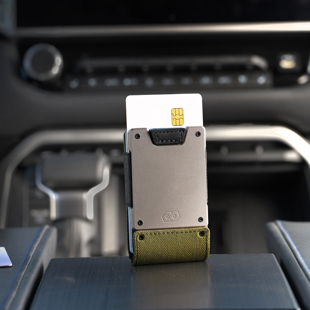 olive green proof wallet with credit card in holder on a car dashboard