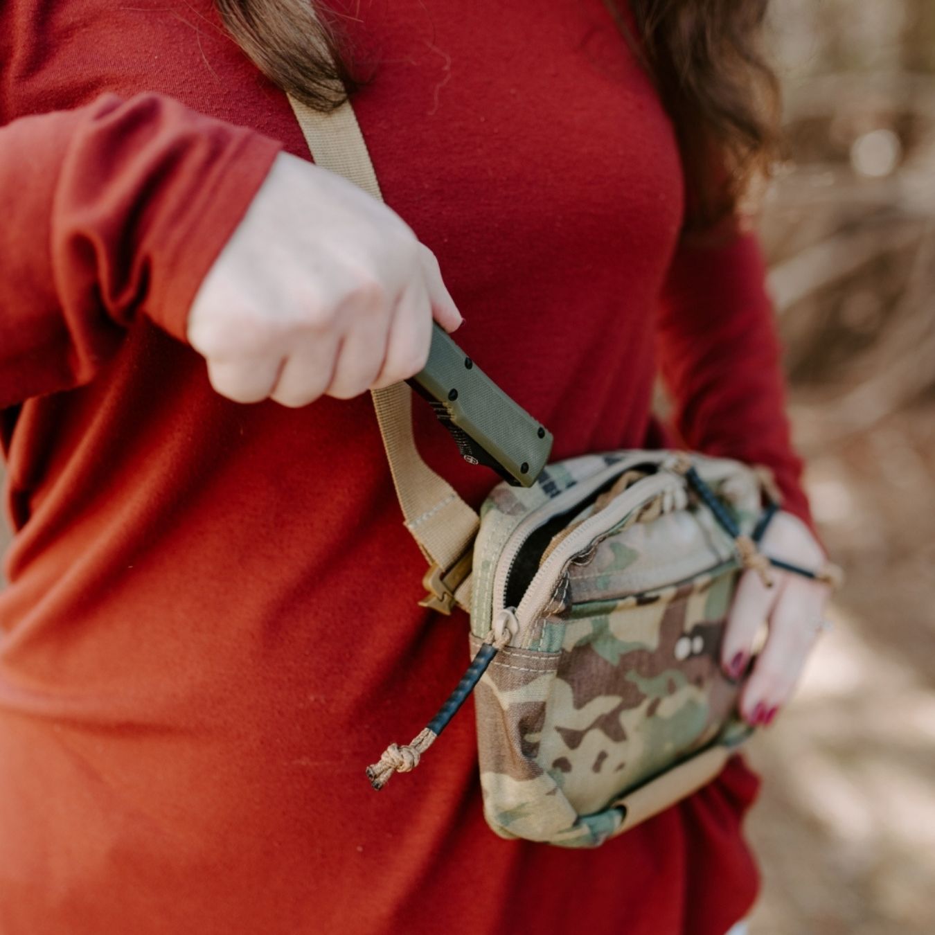 woman carrying the green ranger otf knife in camo shoulder bag